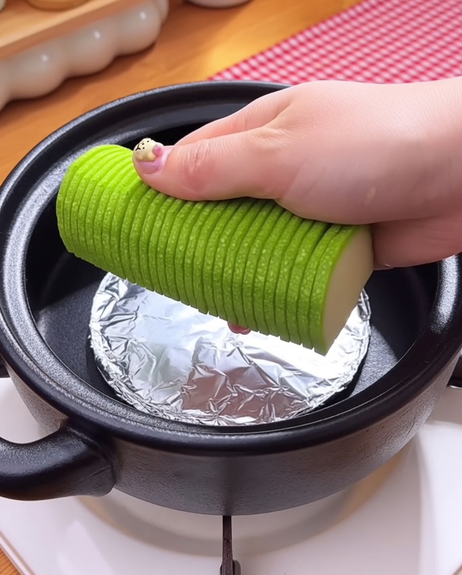 Grzyby enoki i surowe małże dodawane do garnka na warstwę warzyw.