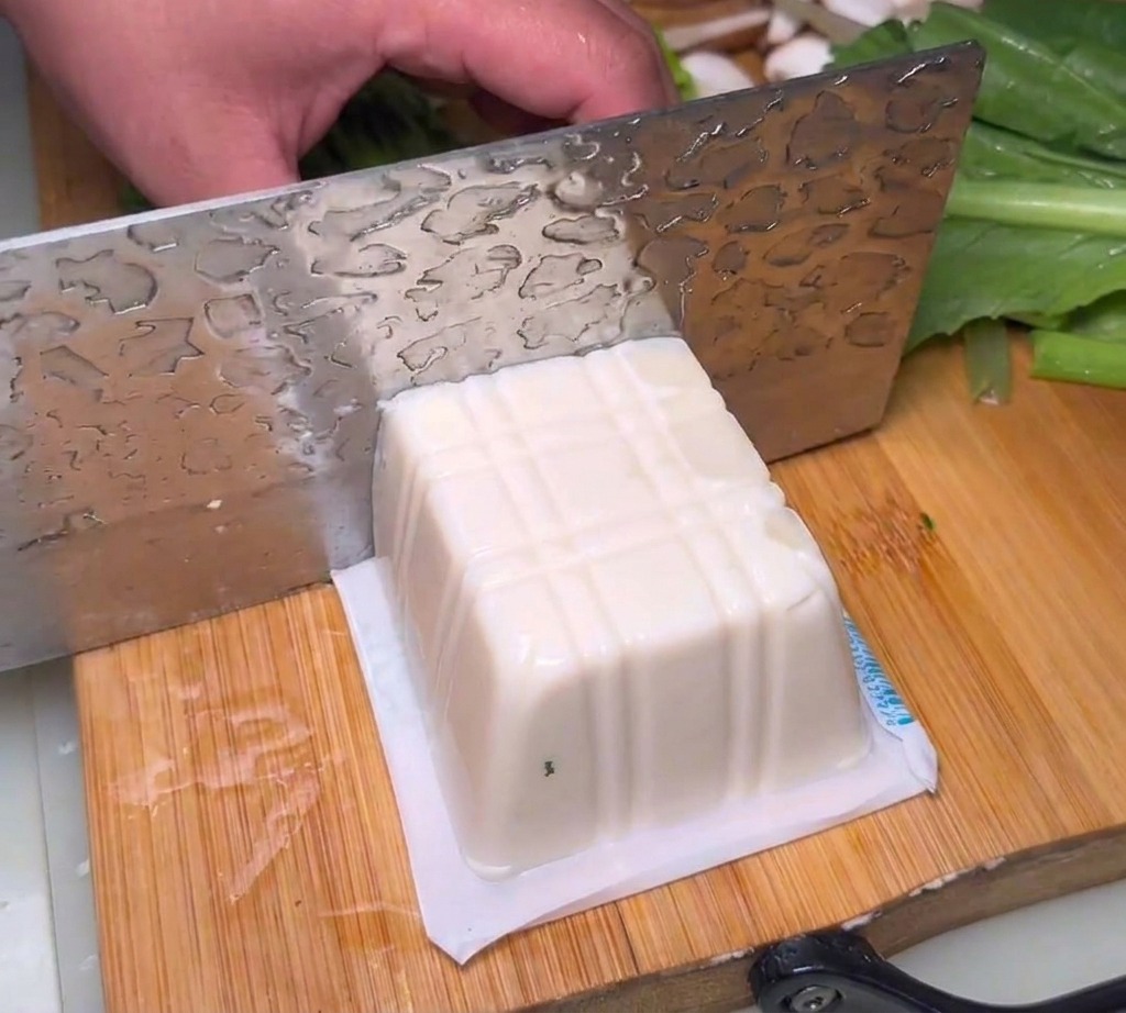 Bloki jedwabistego tofu pokrojone na desce.