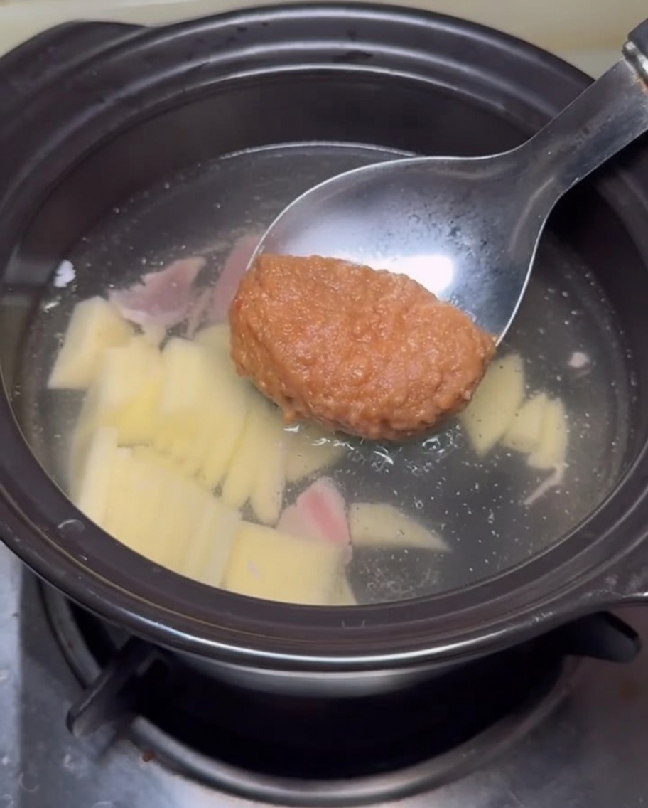 Chochla z pastą sojową zanurzana w bulionie.