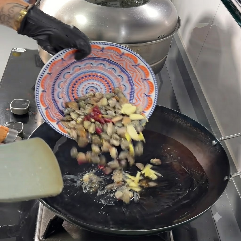 Małże, posiekany czosnek, imbir i suszone papryczki chili zsuwające się z talerza do gorącego woka.