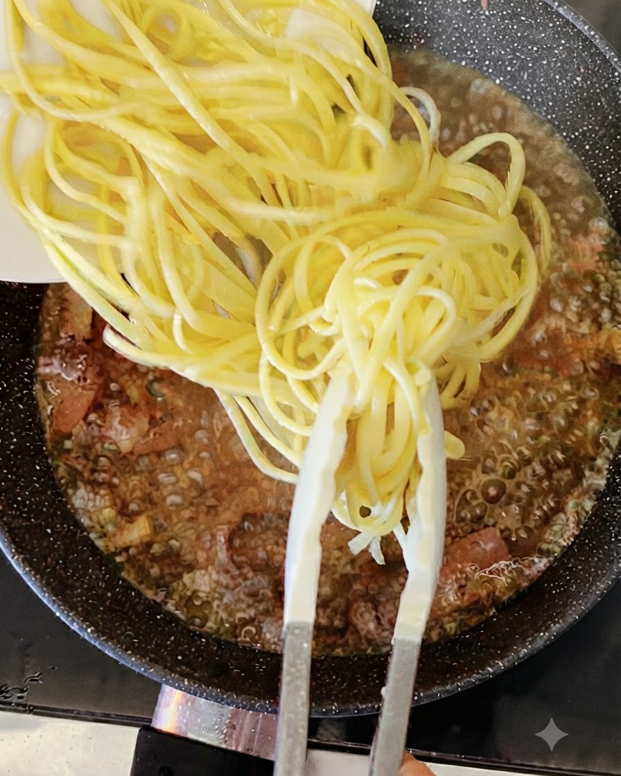 Ugotowane żółte nitki spaghetti dodawane za pomocą szczypiec do bulgoczącej patelni z płynem i boczkiem.
