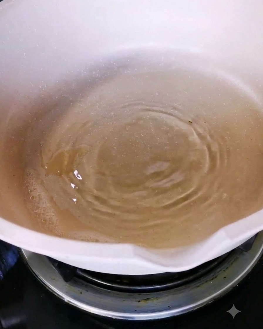 Oliwa z oliwek wlewana do białego ceramicznego patelni na palniku kuchenki.