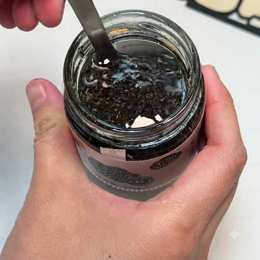 Un petit bol contenant de la sauce aux truffes noires, des jaunes dœufs et du sel mélangés ensemble avec une cuillère.