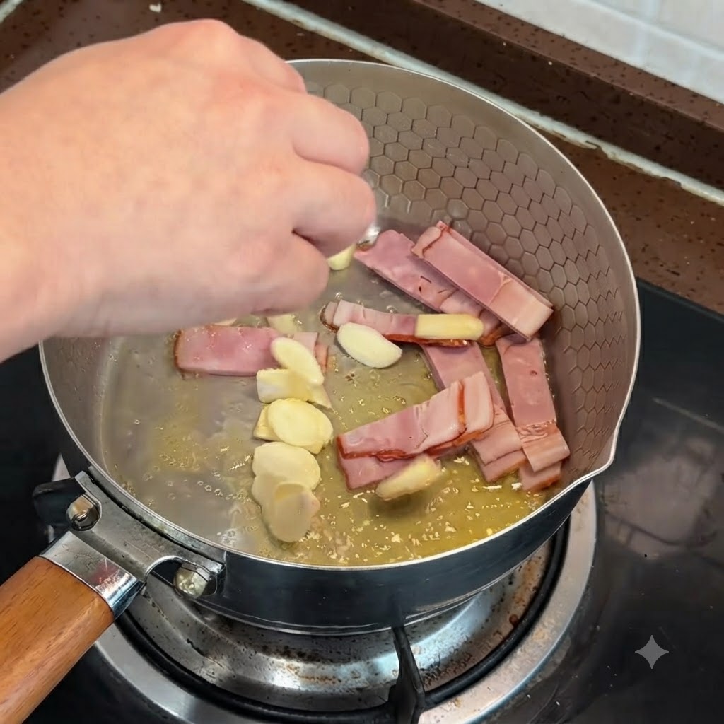 Des tranches de bacon et des morceaux dail en train dêtre sautés dans une poêle avec du beurre fondu.