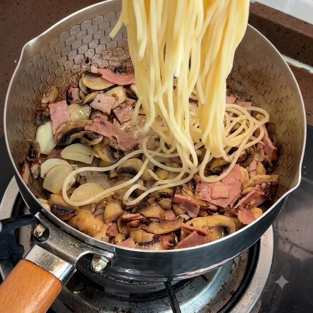 Des spaghettis cuits ajoutés directement dans la poêle avec le bacon et les champignons.