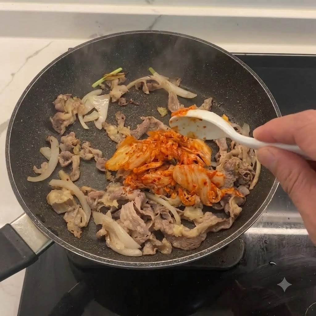 Posiekane kimchi mieszane na patelni z wołowiną i cebulą.