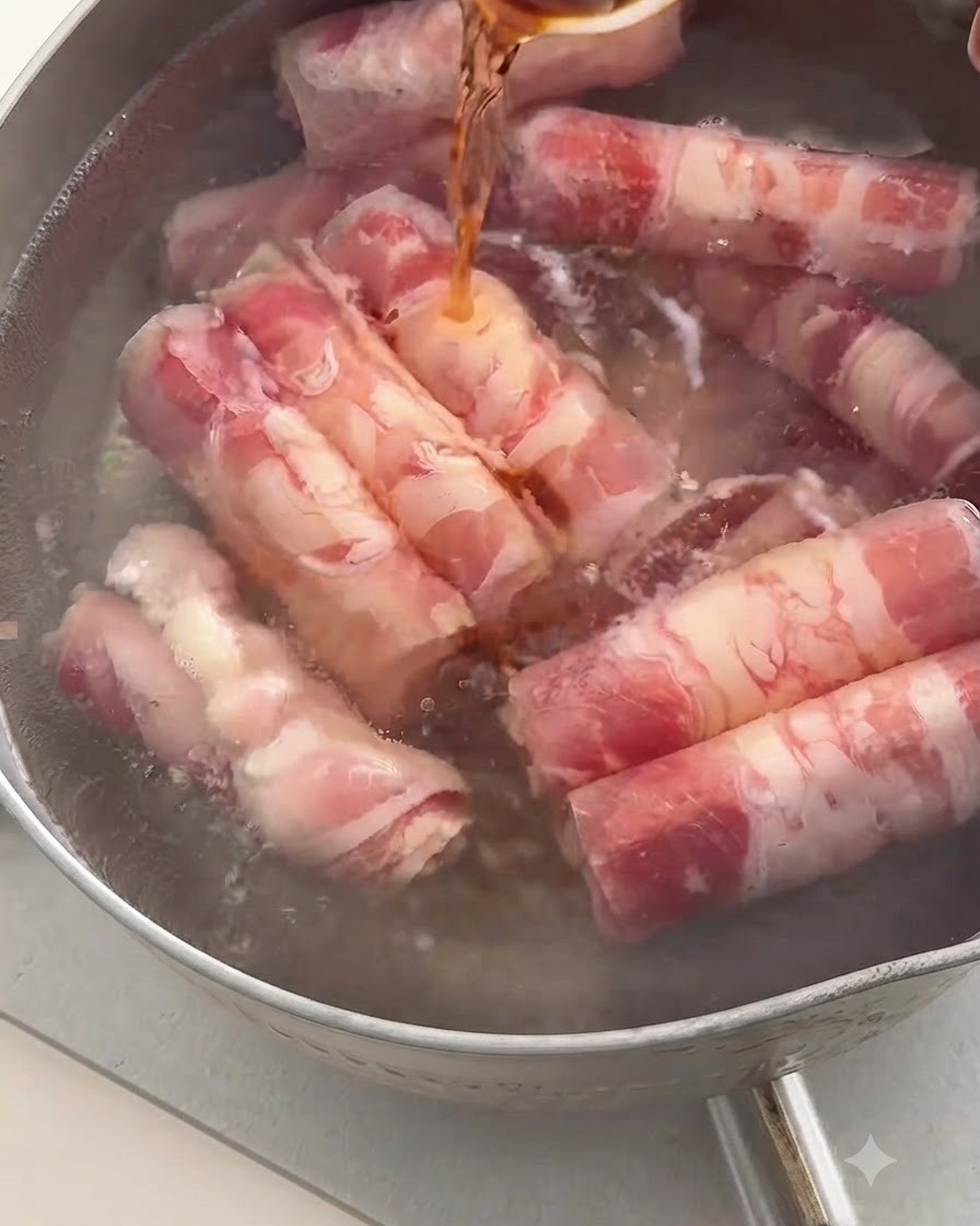 Ciemne wino do gotowania wylewane łyżką do garnka z wrzącą wodą zawierającą rolady wołowe.