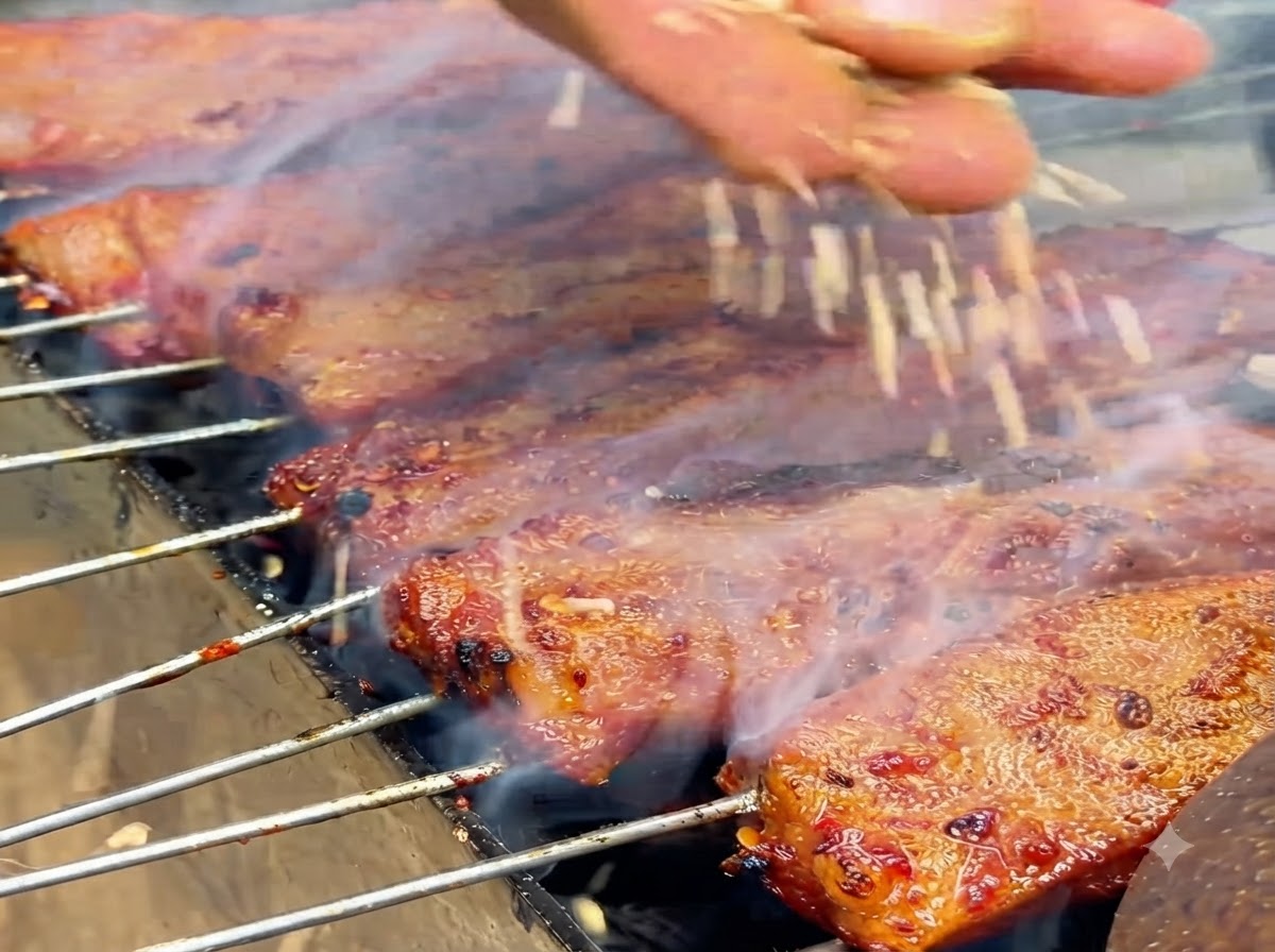 Białe nasiona sezamu wpadające na błyszczące, ugotowane żeberka na grillu.