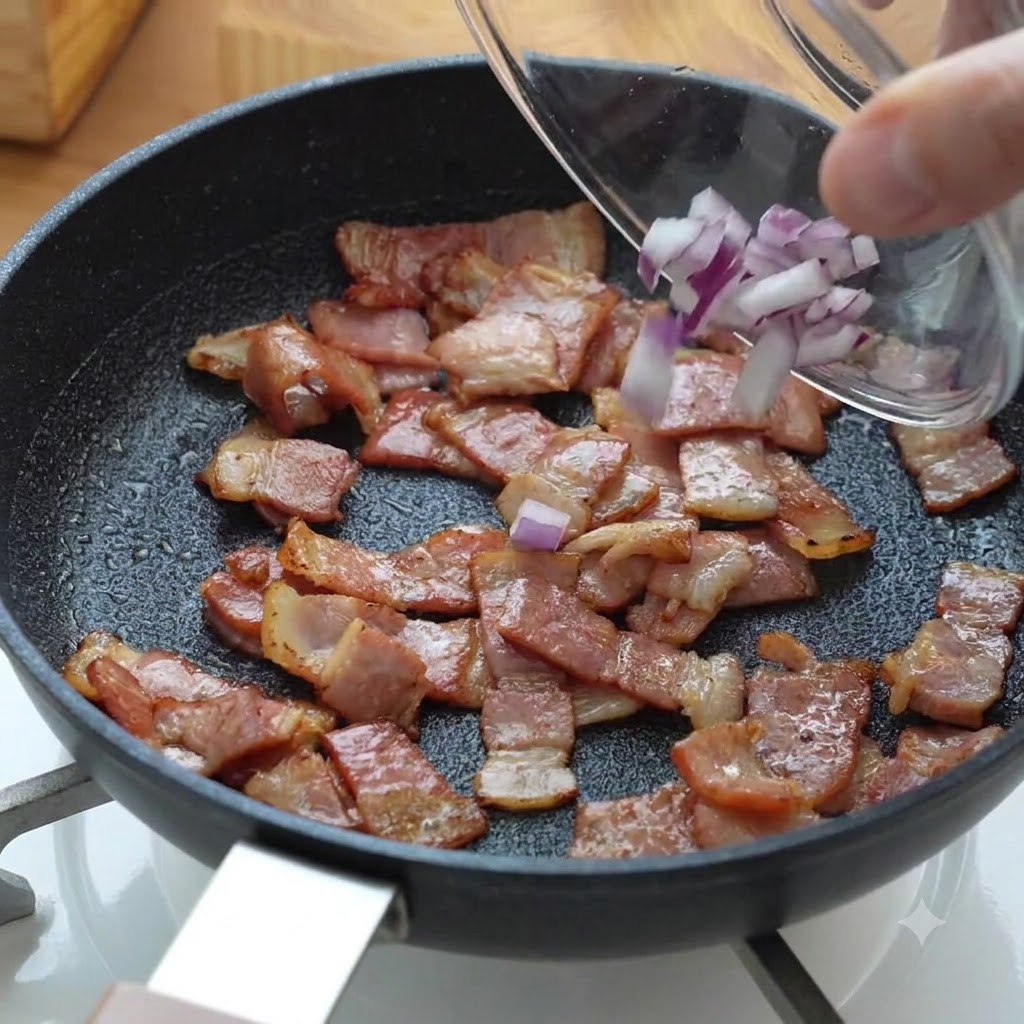 Kawałki posiekanej czerwonej cebuli wsypywane na patelnię do smażącego się boczku.