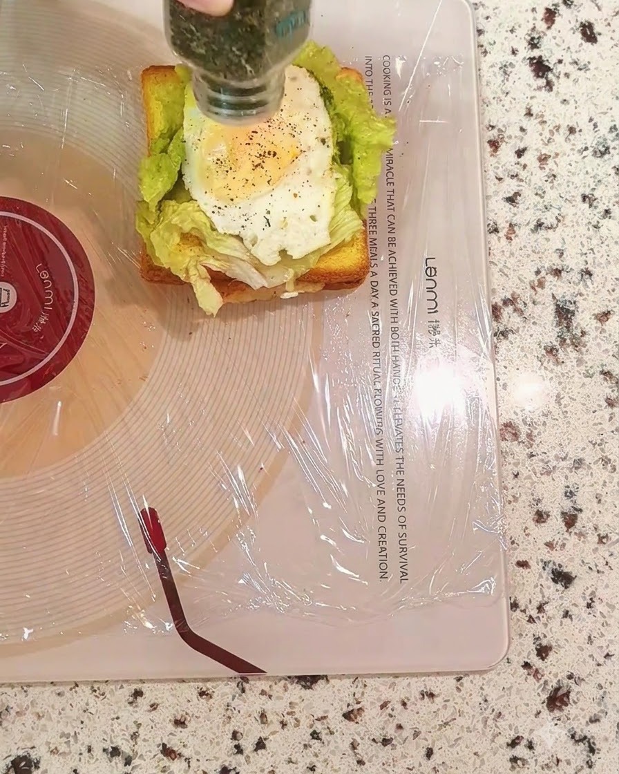 Posypywanie suszoną pietruszką z buteleczki warstwy jajka w kanapce.