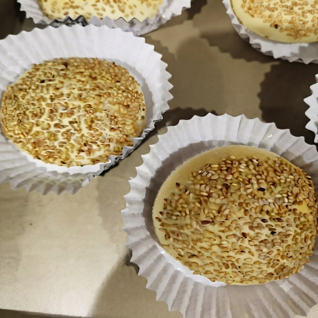 Kotlety burgerowe smażące się w osobnych sekcjach patelni czterodzielnej na kuchence.