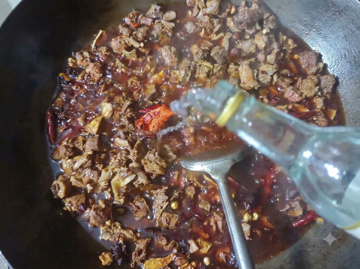 Butelka wlewająca czyste baijiu do woka wypełnionego duszącym się mięsem i przyprawami.