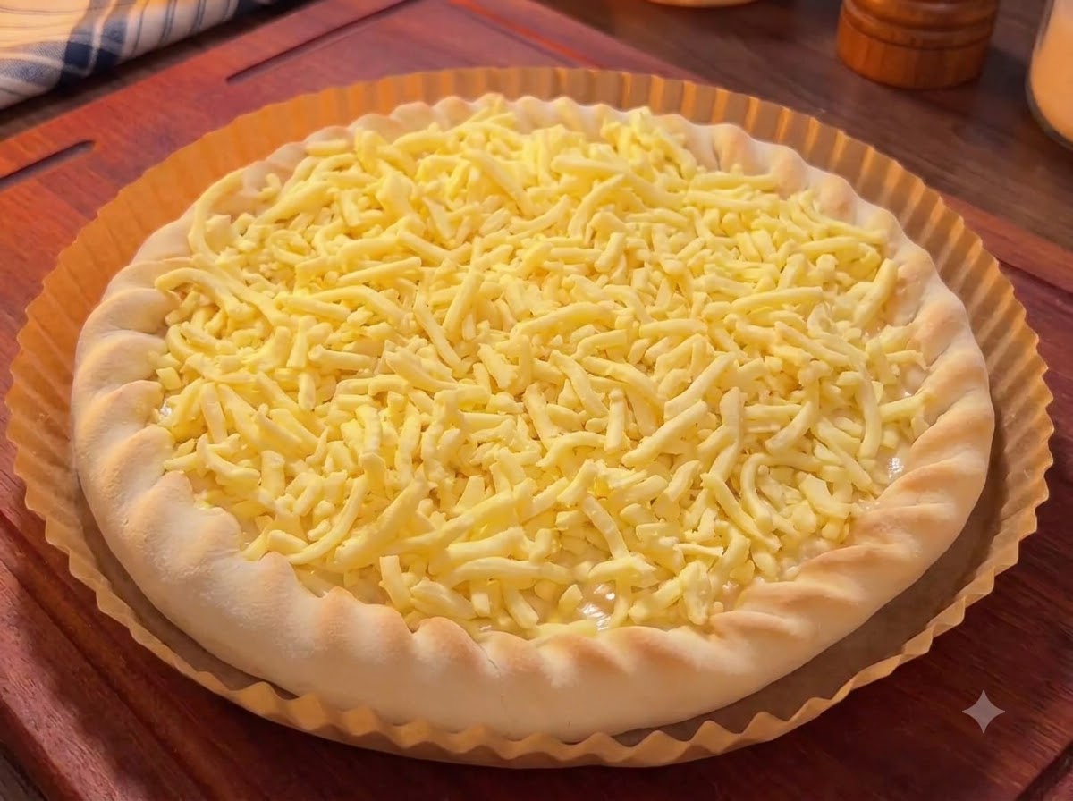Spód pizzy pokryty startym serem, przystrojony kolorowymi kawałkami mango, smoczego owocu i wiśniami.