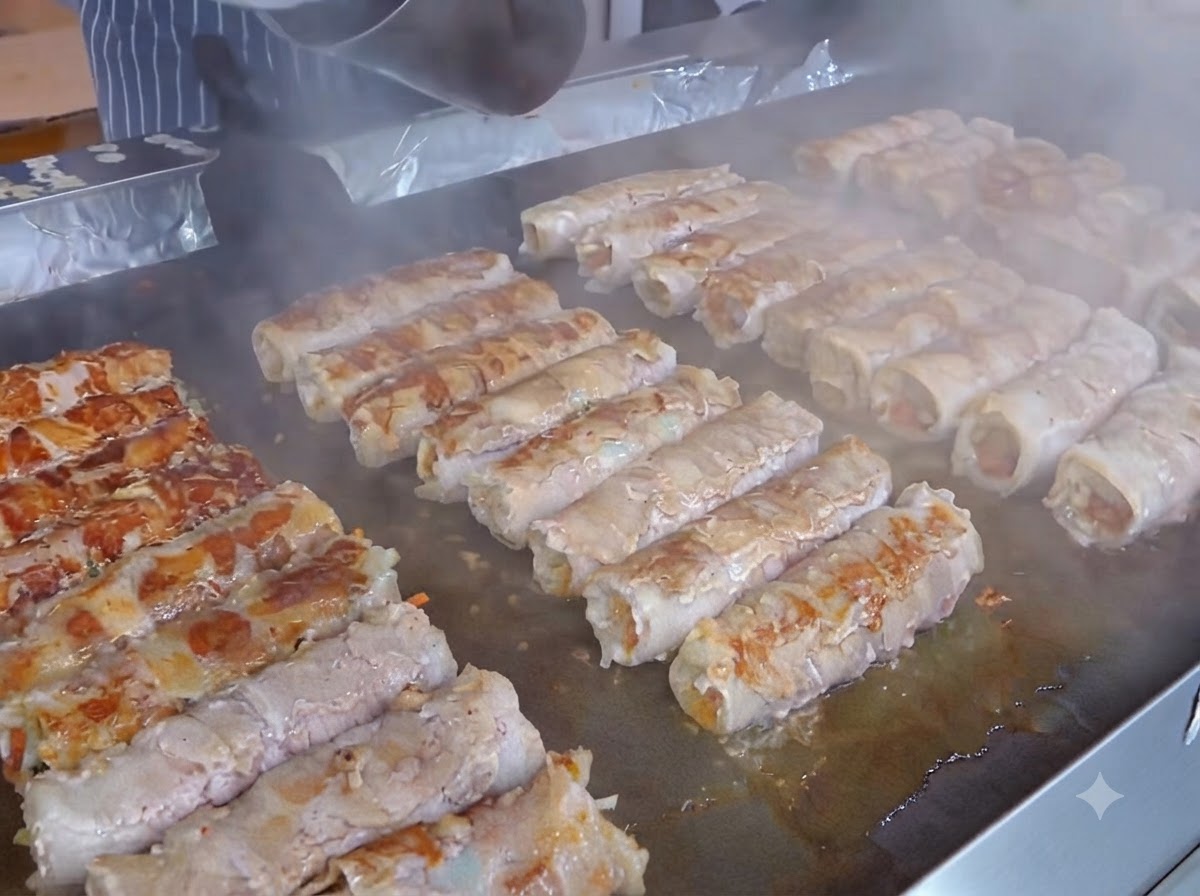 Plaster żółtego sera umieszczany na warstwie kimchi na przygotowanych rolkach mięsnych.