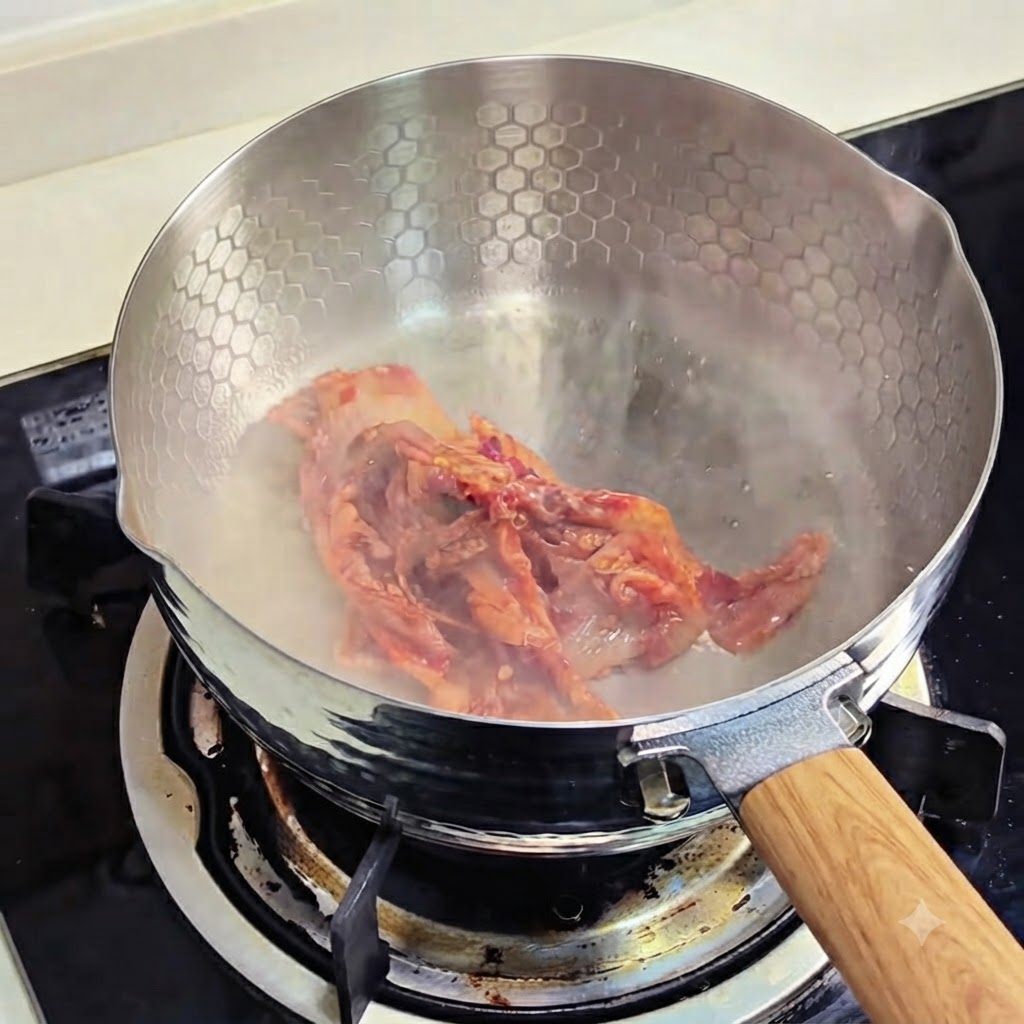 Kawałki kimchi skwierczące i smażące się na patelni.