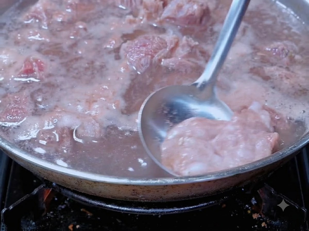 Chochla zbierająca pianę z gotującej się wołowiny w garnku.