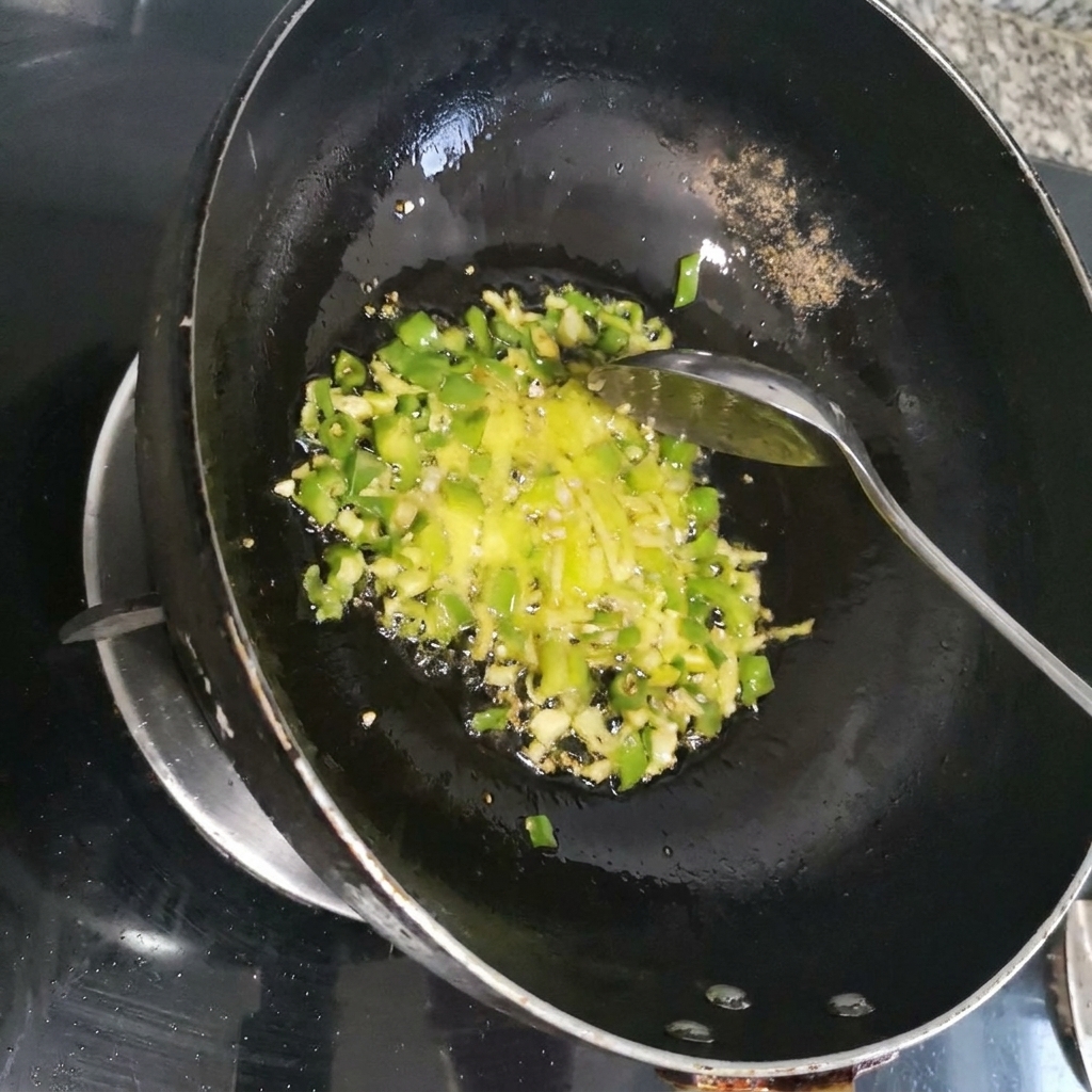 Posiekana czerwona papryczka chili smażona razem z zielonymi aromatami w ciemnym woku.