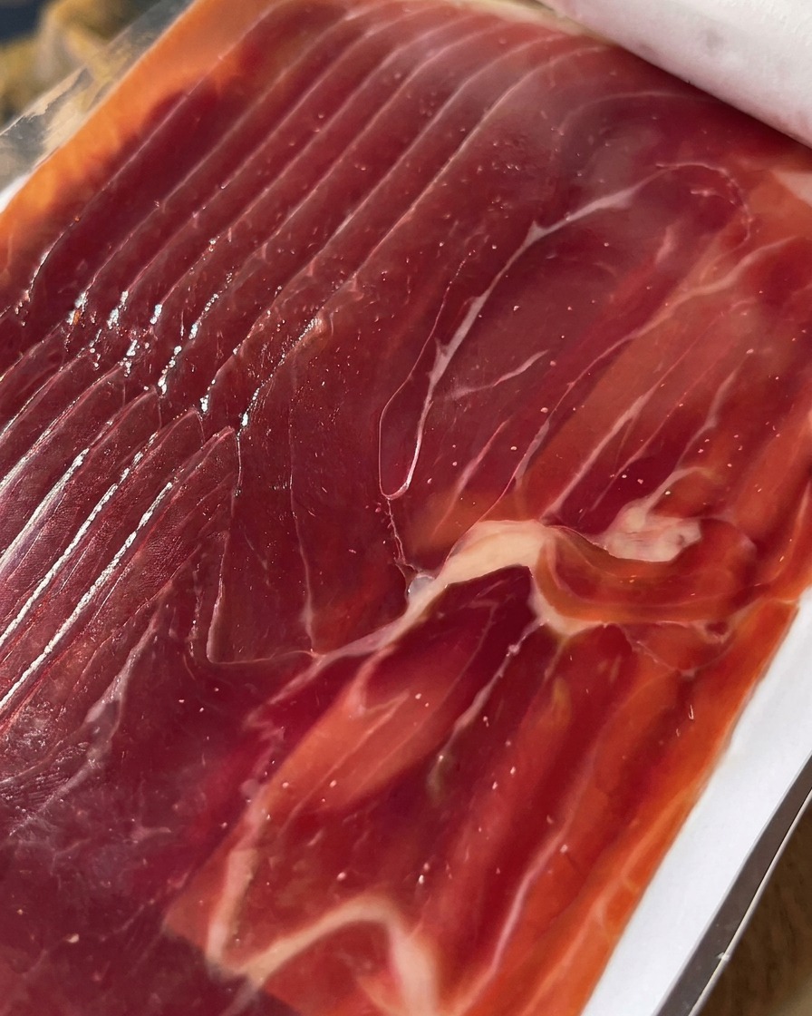 Zbliżenie starannie pokrojonego prosciutto gotowego do ułożenia na figach.