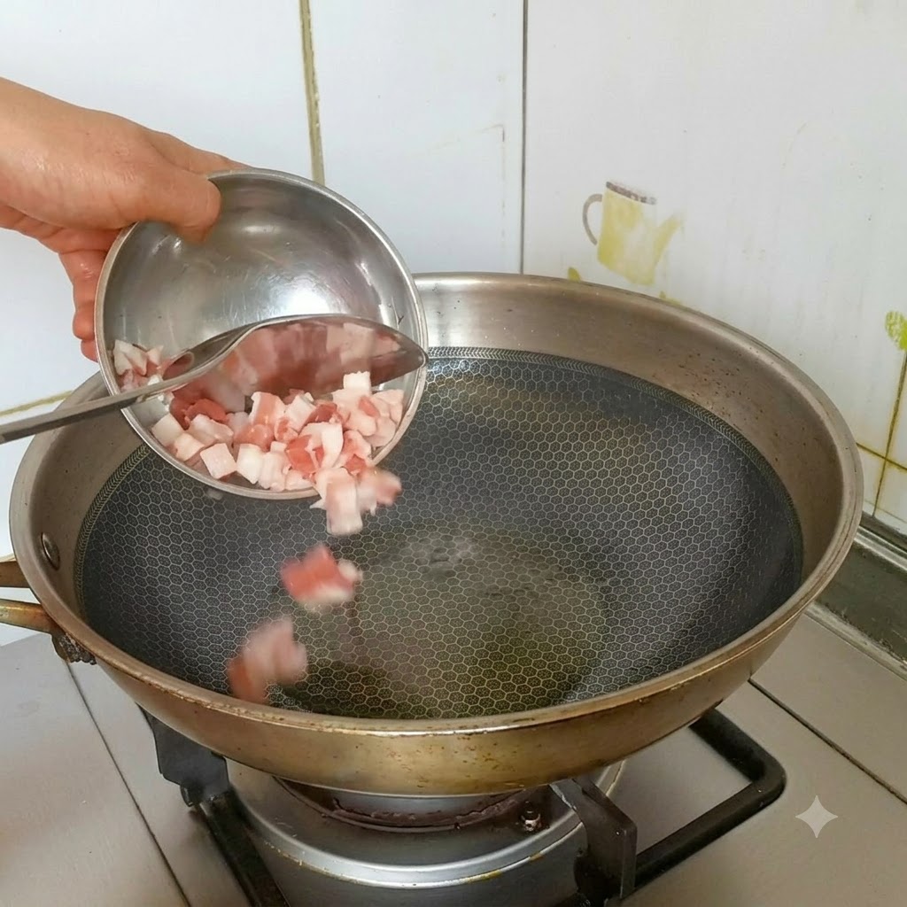 Pokrojony w kostkę boczek wsypywany z małej miseczki do rozgrzanego woka z olejem.