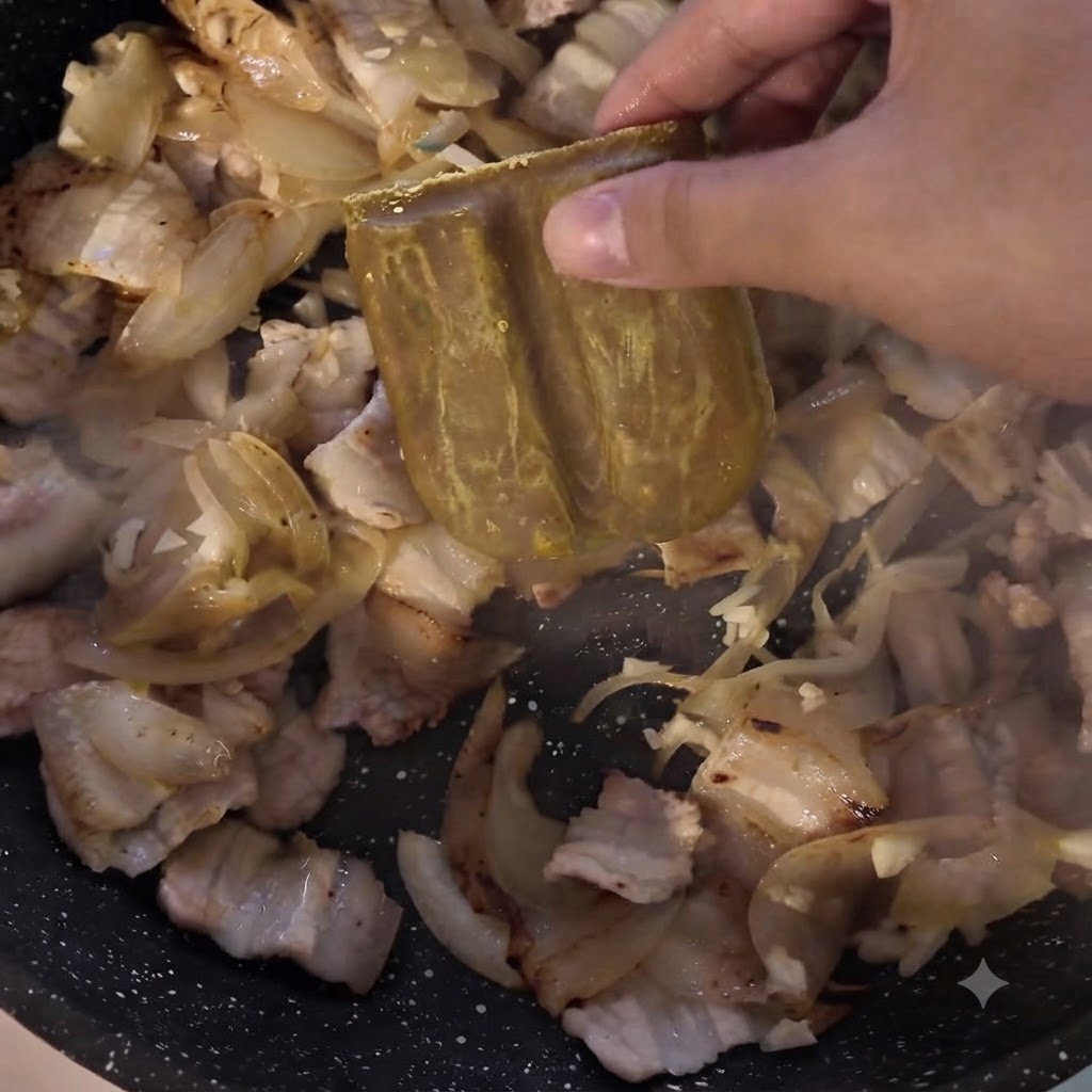 Kostka pasty curry dodawana na patelnię z mięsem i cebulą.