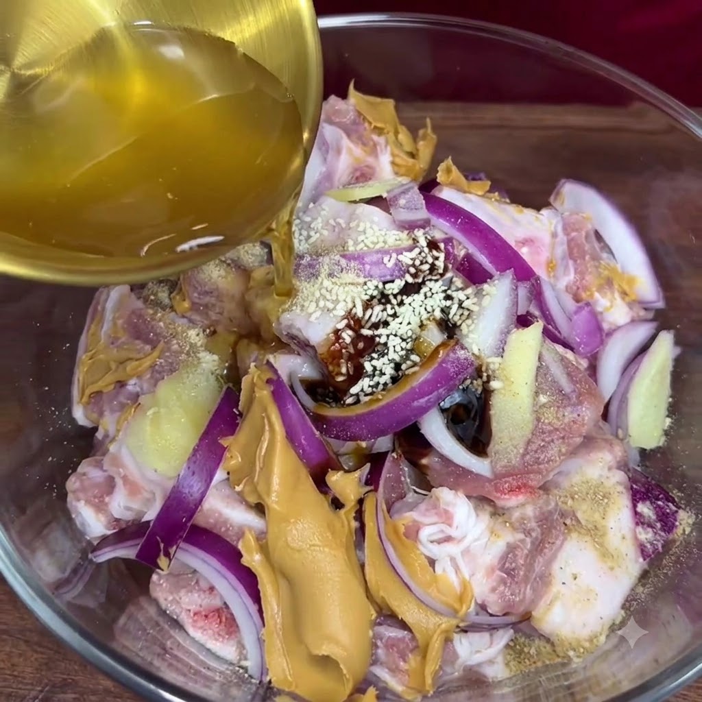 Złocisty sok czosnkowy wlewany z chochelki do szklanej miski zawierającej doprawione żeberka i inne składniki marynaty.