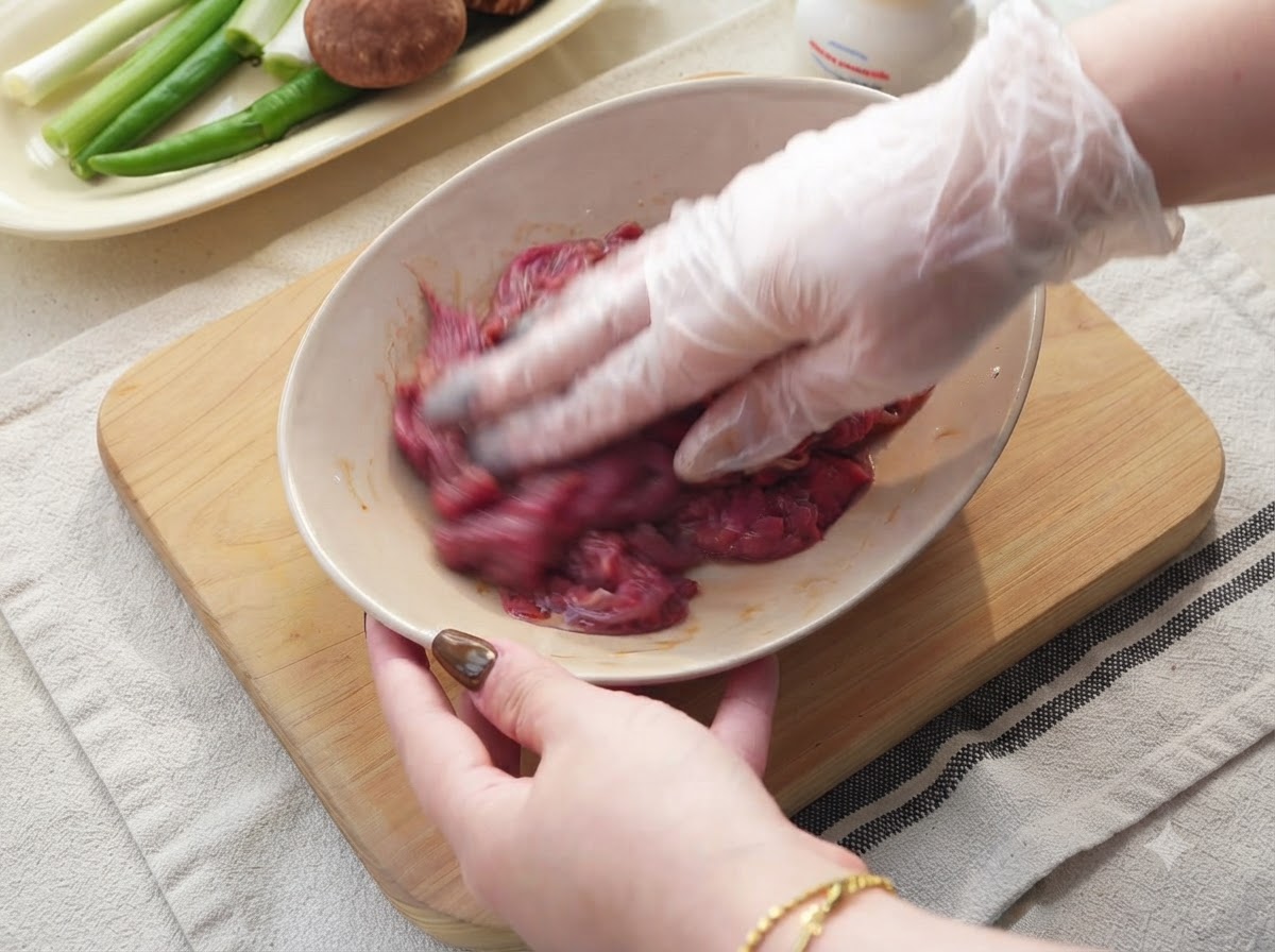 Cebula, zielone chili i czosnek krojone na drewnianej desce do krojenia.