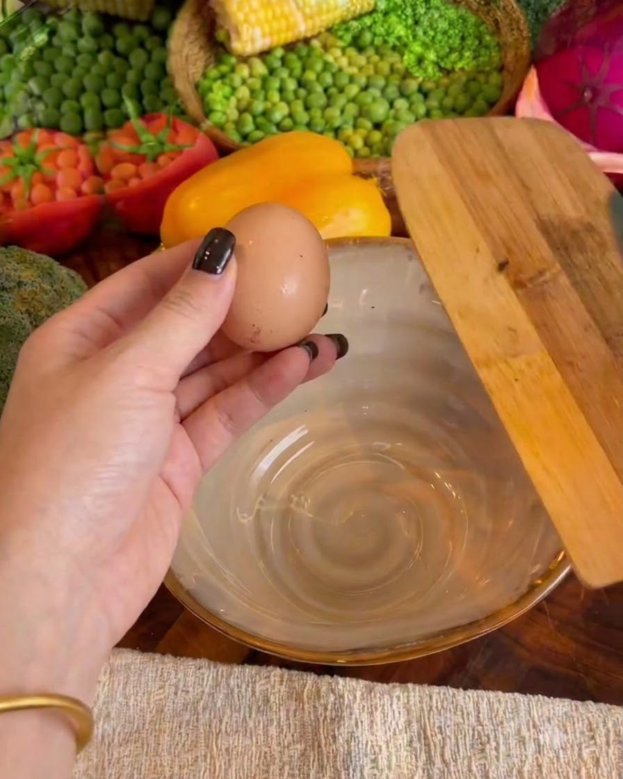 Dwa jajka rozbite w ceramicznej misce z dolewanym mlekiem.
