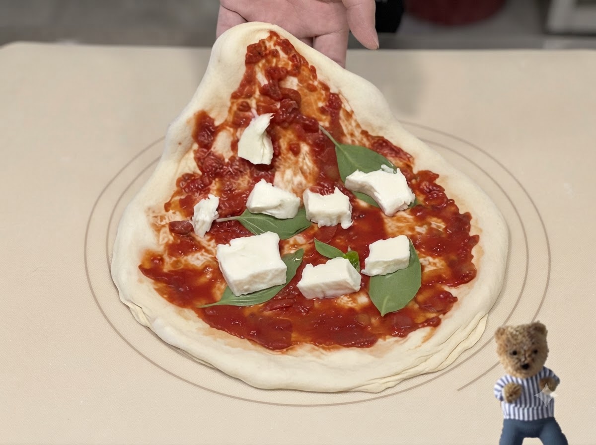 Metalowa łopata do pizzy wsuwająca się pod przygotowaną pizzę z sosem, bazylią i serem.